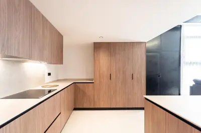 a kitchen with wooden cabinets and white counters at Aqua Suites Ciudad de las Artes I in Valencia