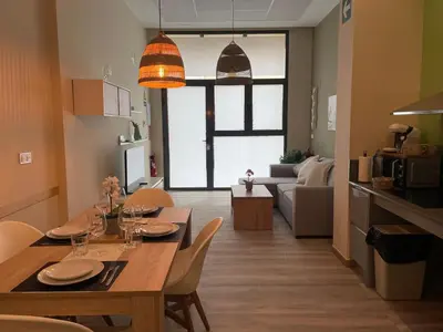 a kitchen and living room with a table and chairs at Fabuloso apartamento en Ruzafa in Valencia