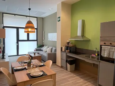 a kitchen and a living room with a table and chairs at Fabuloso apartamento en Ruzafa in Valencia