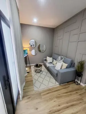 a living room with a blue couch and a mirror at Charming Urban Stay in Valencia in Valencia