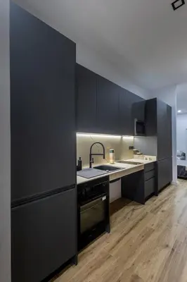 a kitchen with black cabinets and a sink at Charming Urban Stay in Valencia in Valencia
