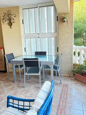 a table and chairs in a patio with a window at Bahia Park Résidence in Cullera