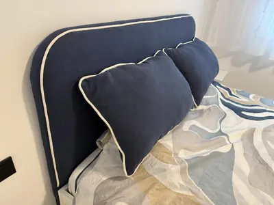 a bed with blue pillows on top of it at Cómodo Apartamento cerca de la playa de San Antonio, dos baños in Cullera