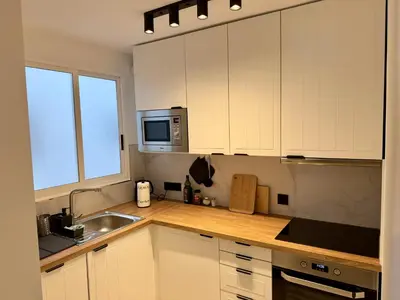 a kitchen with white cabinets and a sink and a microwave at Cómodo Apartamento cerca de la playa de San Antonio, dos baños in Cullera