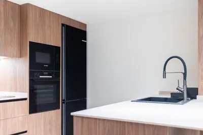 a kitchen with a black refrigerator and a sink at Aqua Suites Ciudad de las Artes II in Valencia
