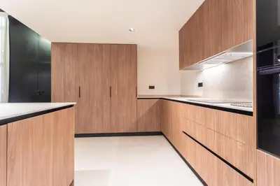 a kitchen with wooden cabinets and a black refrigerator at Aqua Suites Ciudad de las Artes II in Valencia