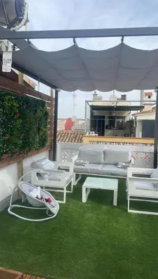 a patio with white furniture and green grass at Stylish and renovated house in Cullera