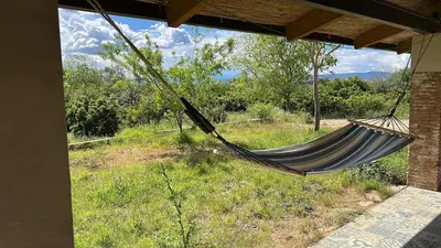 a hammock hanging from a porch of a house at Hort de les Oronetes in Alzira