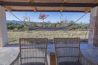 two chairs and a hammock on a porch at Hort de les Oronetes in Alzira