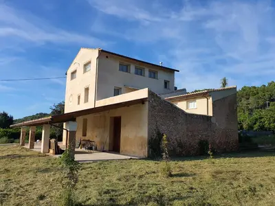 a house with a brick wall in a field at Hort de les Oronetes in Alzira