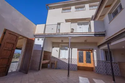 a house with a balcony and a wooden door at Hort de les Oronetes in Alzira