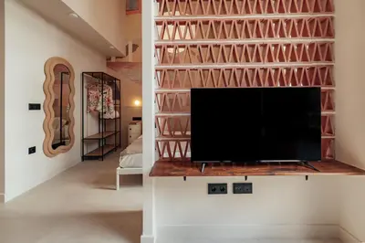 a living room with a tv and a wall with a built in shelf at The Atelier Lofts in Valencia