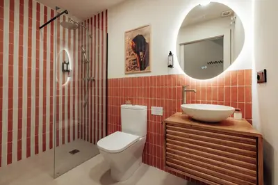 a bathroom with a toilet and a sink and a mirror at The Atelier Lofts in Valencia