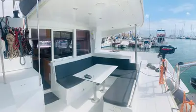 a bench on the back of a boat in the water at Catamaran Nora in Puebla de Farnals