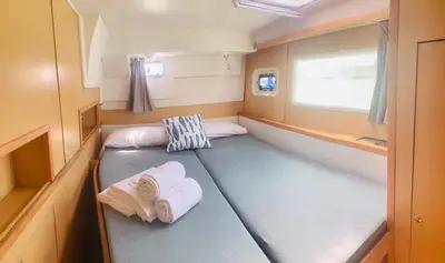 a small room with two beds and towels at Catamaran Nora in Puebla de Farnals