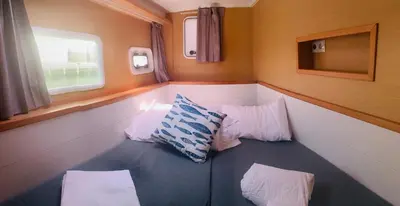 a small room with two pillows on a train at Catamaran Nora in Puebla de Farnals