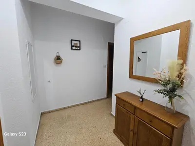 a hallway with a mirror and a wooden dresser at Apartamento playa Valencia in Mareny Barraquetas
