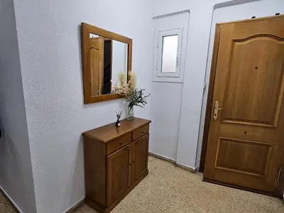 a bathroom with a dresser and a mirror and a door at Apartamento playa Valencia in Mareny Barraquetas