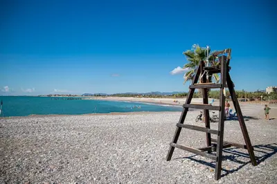 a wooden ladder sitting on a beach next to the water at Planta baja en pleno centro de la playa in Moncófar