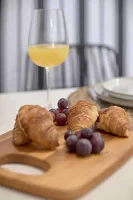 a wooden cutting board with pastries and a glass of wine at Romantic Suite Roig Arena N4 Virkin Suites in Valencia