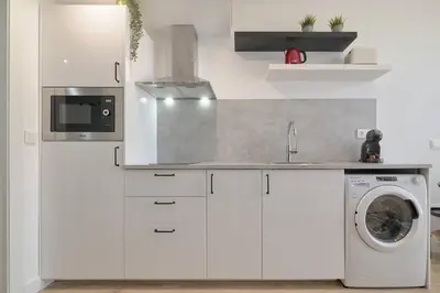 a kitchen with white cabinets and a washer at Romantic Suite Roig Arena N4 Virkin Suites in Valencia