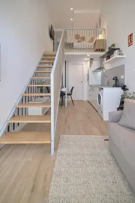 a living room with a staircase leading to a kitchen at Romantic Suite Roig Arena N4 Virkin Suites in Valencia
