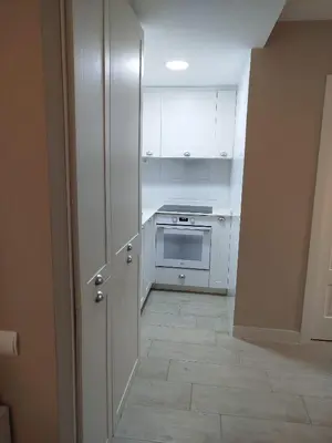 a kitchen with white cabinets and a stove at Cullera Playa de los Olivos Apartment in Faro de Cullera