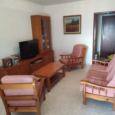 a living room with a tv and a table and chairs at Apartamento primera línea Cullera in Cullera