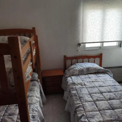 a bedroom with two bunk beds and a window at Apartamento primera línea Cullera in Cullera