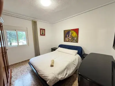 a bedroom with a bed with two night stands and a mirror at La casa del señorito in Tous