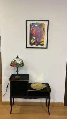 a table with a lamp and a painting on a wall at Hostal Casa Sifre in Villanueva de Castellón
