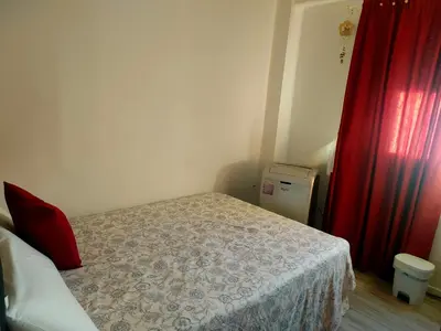 a bedroom with a bed and a red curtain at Habitacion cerca a Ciudad de las Artes y las Ciencias in Valencia