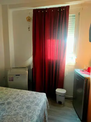 a bedroom with a red curtain and a window at Habitacion cerca a Ciudad de las Artes y las Ciencias in Valencia
