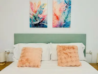 a bed with two pillows and two paintings on the wall at ABAT 1 Cool & Wide Flat next to the Cathedral in Valencia