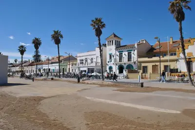 a street in a town with palm trees and buildings at RelaxUp Apartment Patacona Beach in Valencia