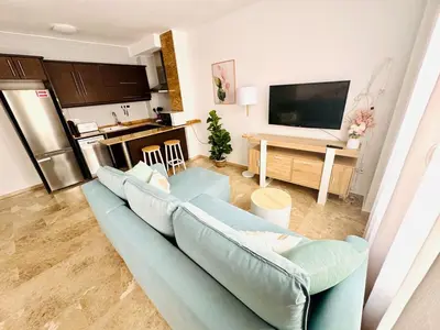 a living room with a blue couch and a kitchen at ABAT 2 Cool & Wide Flat next to the Cathedral in Valencia