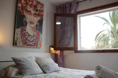 a bedroom with a bed and a window and a painting at Puebla de Farnals playa- Oasis Apartments - Costa de Valencia Beachside Stay in Puebla de Farnals