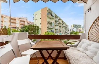 a wooden bench on a balcony with a building at Puebla de Farnals playa- Oasis Apartments - Costa de Valencia Beachside Stay in Puebla de Farnals