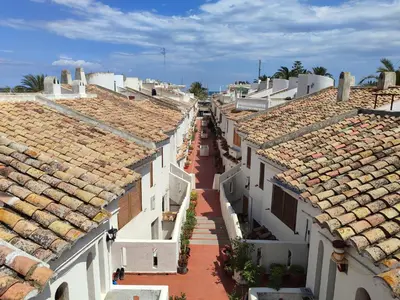 a row of white buildings with tile roofs at Puebla de Farnals playa- Oasis Apartments - Costa de Valencia Beachside Stay in Puebla de Farnals