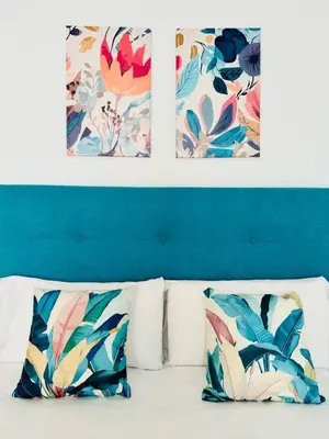 a bed with two pillows and paintings on the wall at ABAT 4 Cool & Wide Studio in the Historic Center in Valencia