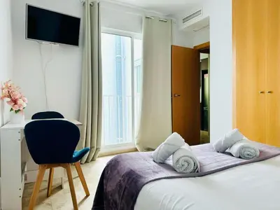 a bedroom with a bed and a chair and a window at ABAT 4 Cool & Wide Studio in the Historic Center in Valencia