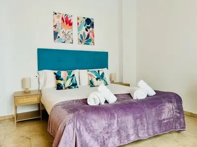 a bedroom with a large bed with a purple blanket at ABAT 4 Cool & Wide Studio in the Historic Center in Valencia