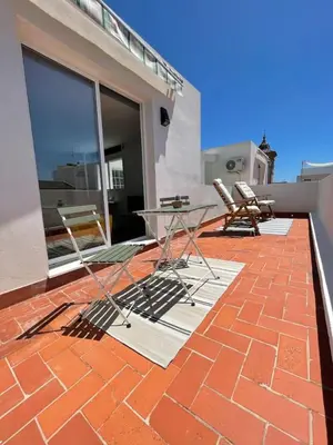 a patio with chairs and a table on a brick floor at More then a bright studio in Godella