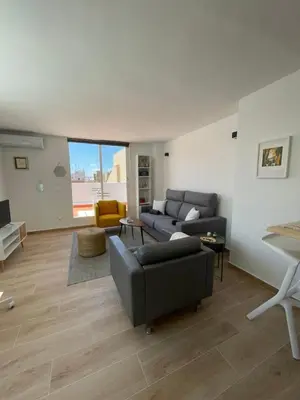 a living room with a couch and a table at More then a bright studio in Godella