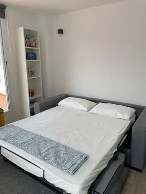 a bed with white sheets and pillows in a room at More then a bright studio in Godella