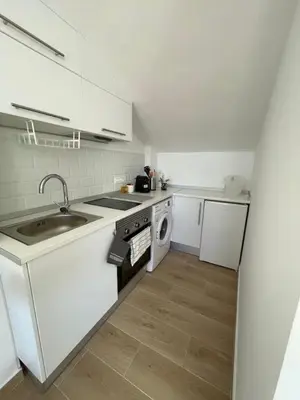 a white kitchen with a sink and a dishwasher at More then a bright studio in Godella
