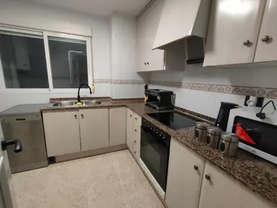 a small kitchen with white cabinets and a sink at Playa Paradis III - Primera linea de playa in Moncófar