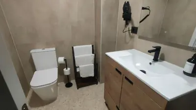 a bathroom with a white toilet and a sink at Playa Paradis III - Primera linea de playa in Moncófar
