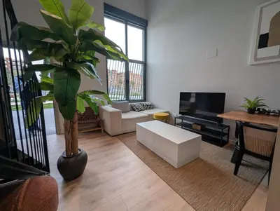 a living room with a plant and a white couch at City of Arts Valencia Flats by Rent Me in Valencia