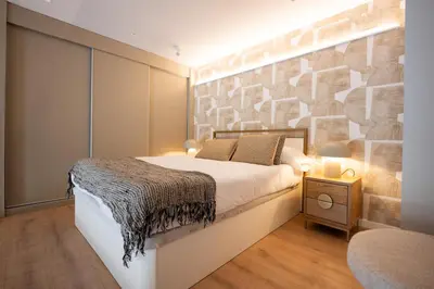 a bedroom with a bed and a stone wall at City of Arts Valencia Flats by Rent Me in Valencia